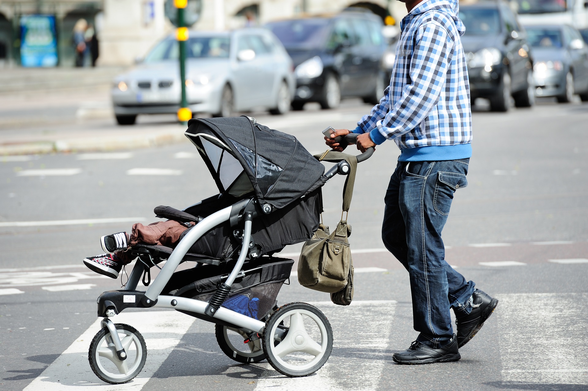 Vater mit Kind im Kinderwagen