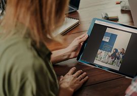 Eine Frau hält ein Touchpad mit der Normungsroadmap Bauwerke auf dem Screen