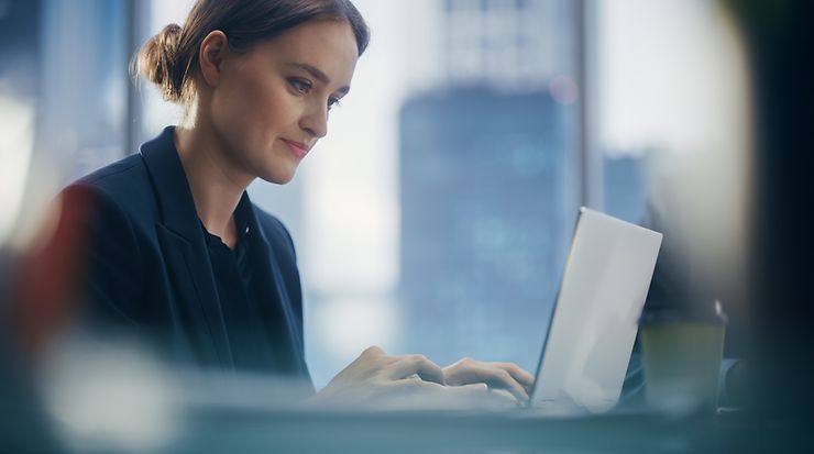 Eine Frau schaut auf ihren Laptop und tippt