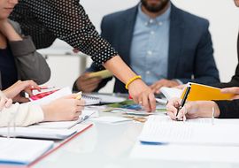 Team-Besprechung im Büro mit Stift und Papier