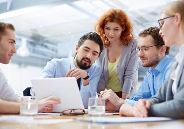 Studierende diskutieren am Laptop