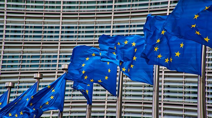 Acht gehisste europäische Flaggen vor Gebäude 